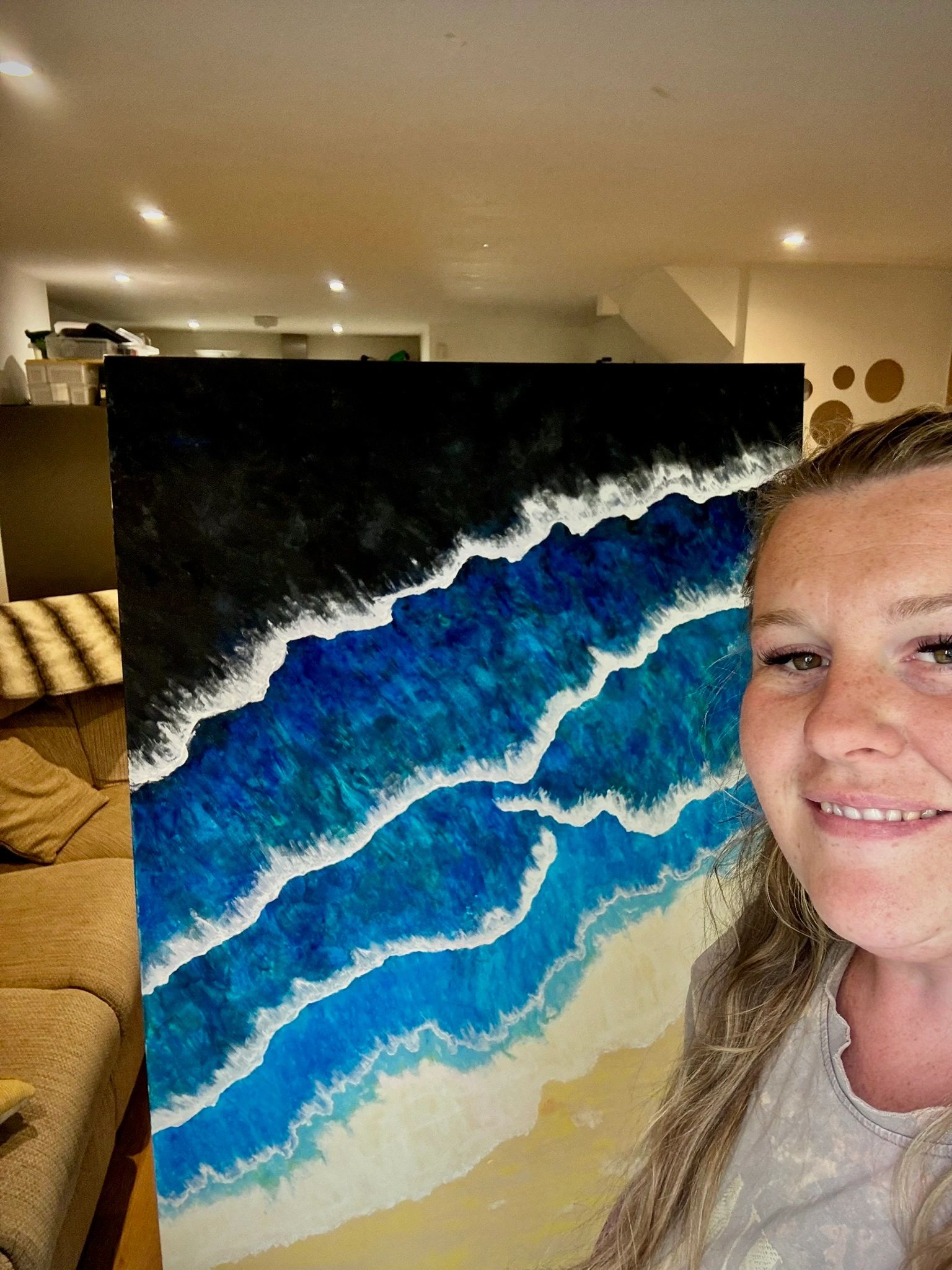 Sophie holding an aerial sea painting