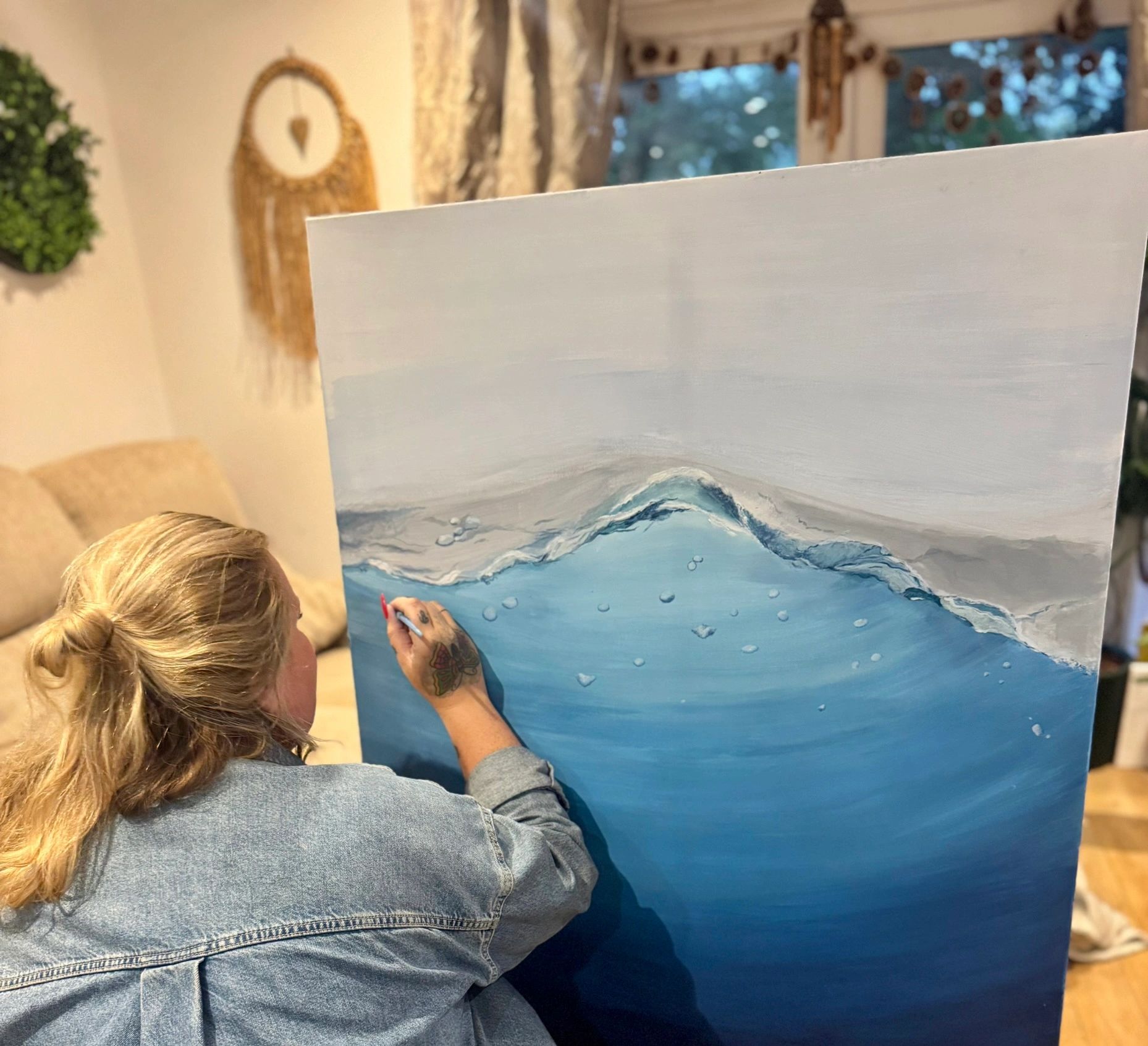 Sophie painting a large wave canvas