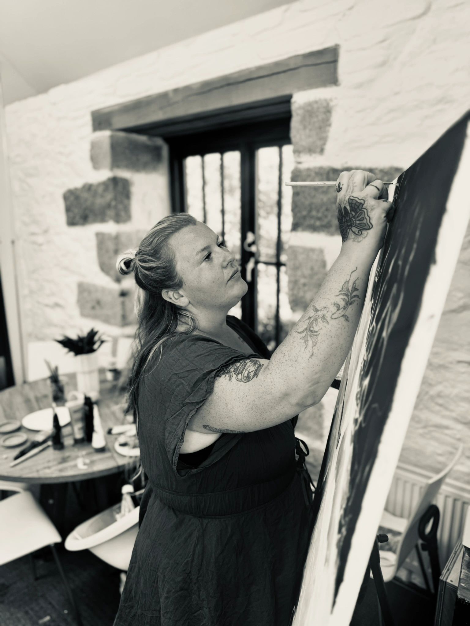 Sophie Ratcliffe painting at her easel in Cornwall
